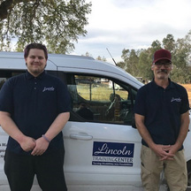 jarrett-brandon standing in front of a Lincon Training Center white vehicle